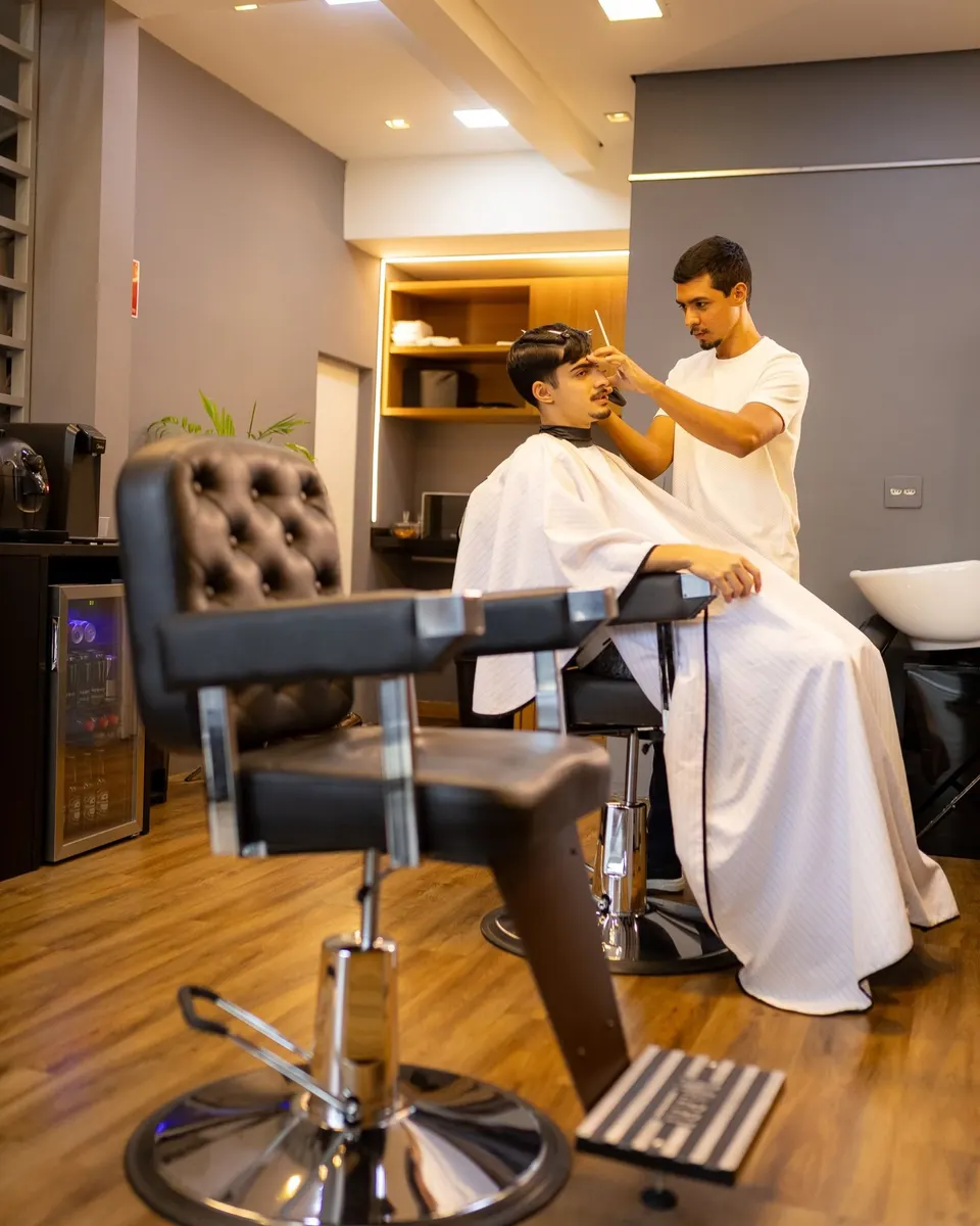 Ryan Gomes cortando o cabelo de um cliente na cadeira do Garimpo Studio